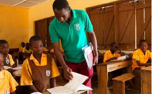 A teacher supervising and helping his students