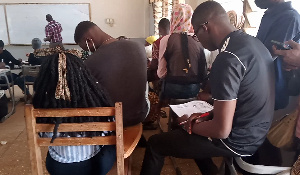 A photo of some students sitting on chair handles