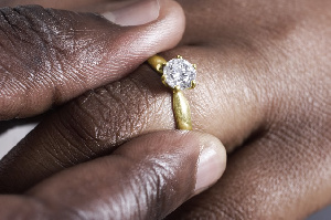 A groom putting a ring on his bride's finger