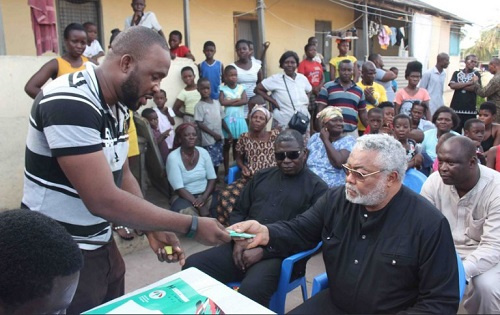 Rawlings receiving his NDC membership card after paying his dues for the next three years