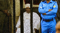 Omar Al-Bashir sat in a cage as he was sentenced for corruption