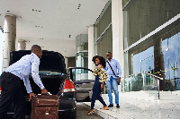 An uber driver helping his passengers with their luggage