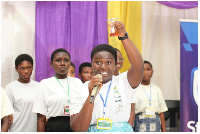 Leader of Group J showing a sample of biodiesel they created from waste cooking oil to the audience