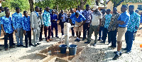 Dr Bandim watches on as a student pump out water from the borehole