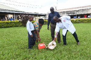 The boy's mother taking the medicine after the drone landed at the hospital