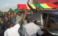 President John Mahama waves at crowds from car.