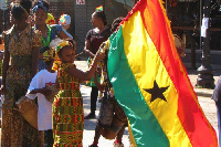 A young girl waves the Ghana flag