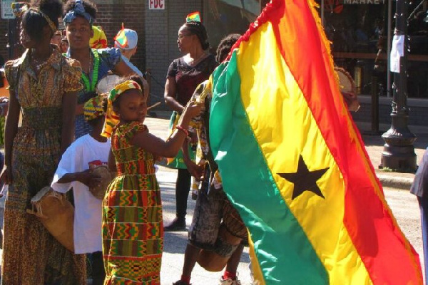 A young girl waves the Ghana flag