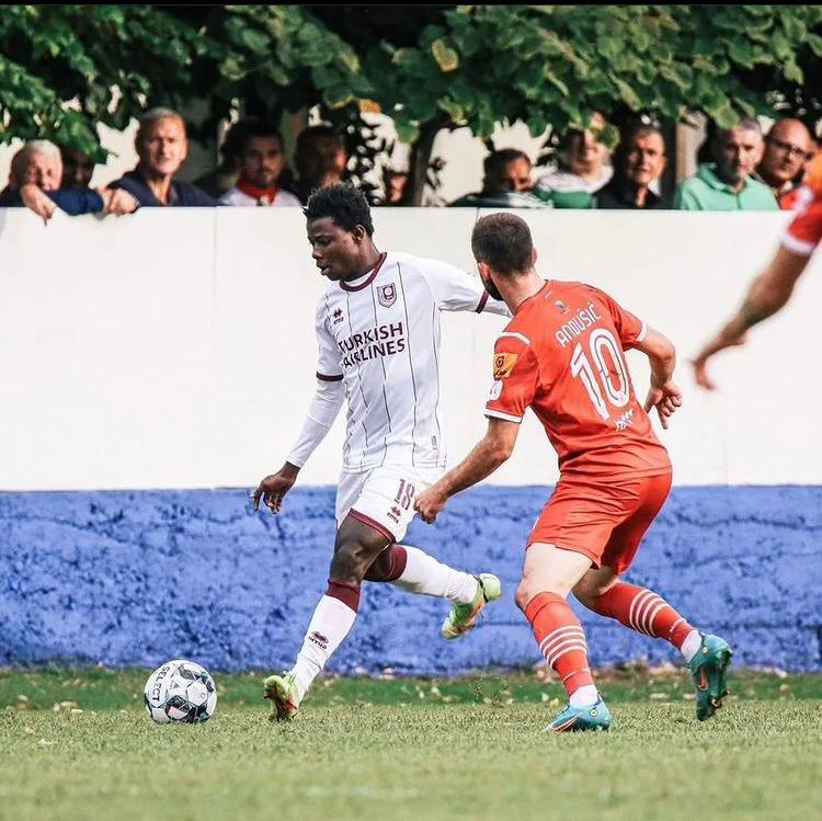 Abdul Rashid Abubakar (in white jersey) attempts to cross the ball