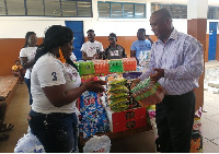 Mr. Freddie Tetteh of the school receiving the donated items from Madam Herty Corgie