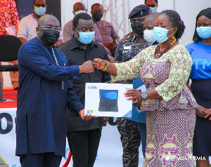 Vice President  Dr. Mahamudu Bawumia presenting a laptio to a teacher