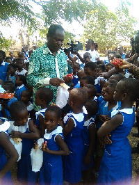 Mr. Joseph Boahen Aidoo distributing chocolate to some pupils