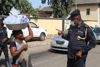 ACP Kwesi Ofori instructing an iced water seller to wear her nose mask. Photo by Seth Osabukle