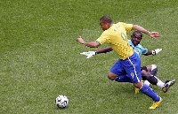 Olele in a challenge with Brazil's Ronaldo for the ball