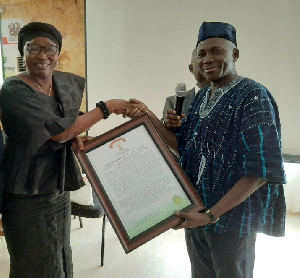 Mr Frank Fuseini Adongo presenting the citation of honour to Madam Victoria Ayamba