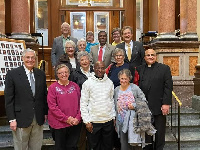 Rev Fr. Raphael Assamah (second right) surrounded by the Iowa State House of Representatives