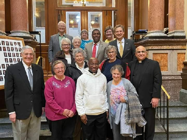 Rev Fr. Raphael Assamah (second right) surrounded by the Iowa State House of Representatives