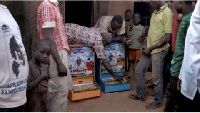 Villagers bring two gambling machines out from a hut in Zamashegu, in Ghana's Northern Region