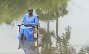 Lady sits in the middle of Bibini River at KNUST