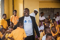 A Stanbic Bank official with some pupils of the Kotobabi Cluster of Schools