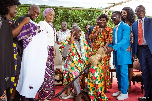 Okyeame Kwame (2 R) presents a sword to John Agyekum Kufour (M) to represent father of creative arts