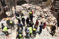 Rescuers search through the rubble of a collapsed five-story apartment building in Cairo