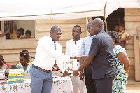 Sam Sarpong, Airtel Ghana handing over the books to Mr. Noah Ayisi (Headmaster of the school)