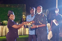 Chief Revenue Officer Geoffrey Oduro Kwaasi (right) presents an award to an officer