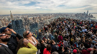 Hundreds watch the sky on the viewing platform of the Edge in New York