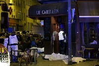 A general view of the scene that shows the covered bodies outside a restaurant following a shooting