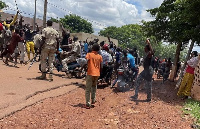 A crowd gathers around a man suspected of taking part in an attack after being beaten by a crowd