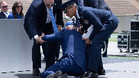 Joe Biden being helped to his feet by aides