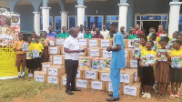 Kwabena Owusu Ababio presenting the books to a school