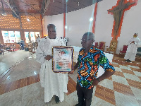 Rev Fr Dominic Apee presenting the citation to Mr James Nsoh, the Patron on St Dominic Savio Mass S