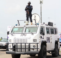 File photo of a police officer standing on an armored truck