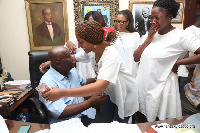 Teary Nana Dokua Akufo-Addo looks on as her sister hugs their father