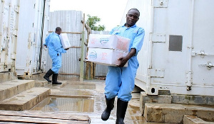 Workers carry tilapia sourced from China at a fish depot in Kisumu.