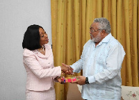 Jean Mensah in a handshake with former president JJ Rawlings