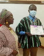 Prof Abena Busia presenting a certificate to a member of the team