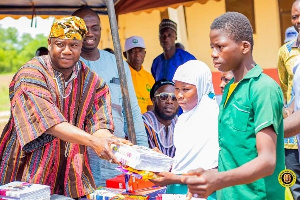 Farouk Aliu Mahama presenting school items to somestudents