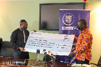 Lands Minister Samuel Jinapor receiving the dummy cheque from Alfred Baku of Gold Fields