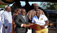 President Akufo-Addo presenting an award to a member of staff