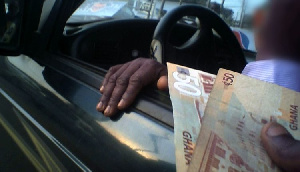 A photo showing someone offering money as bribe