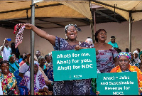 An excited woman displays a placard announcing the Ahotor project