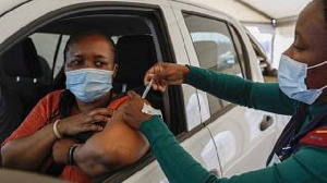 A woman receives a dose of the Johnson and Johnson Covid-19 vaccine from a healthcare worker