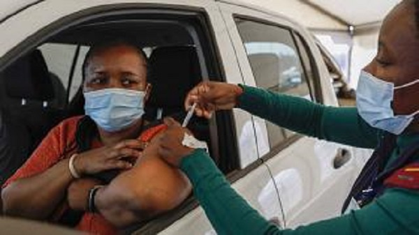 A woman receives a dose of the Johnson and Johnson Covid-19 vaccine from a healthcare worker