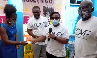 Edith Obeng Hammand (middle) presents a cheque to the founder of the Orphanage