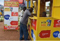 A mobile money vendor attending to a customer