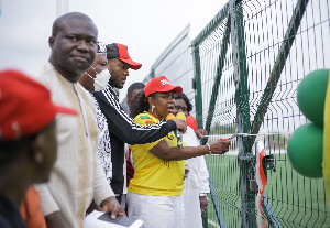 The MP helps cut the tape to inaugurate the turf