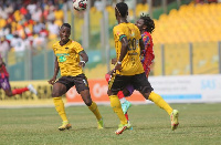 Kotoko players close in on Hearts' Muntari during Super clash